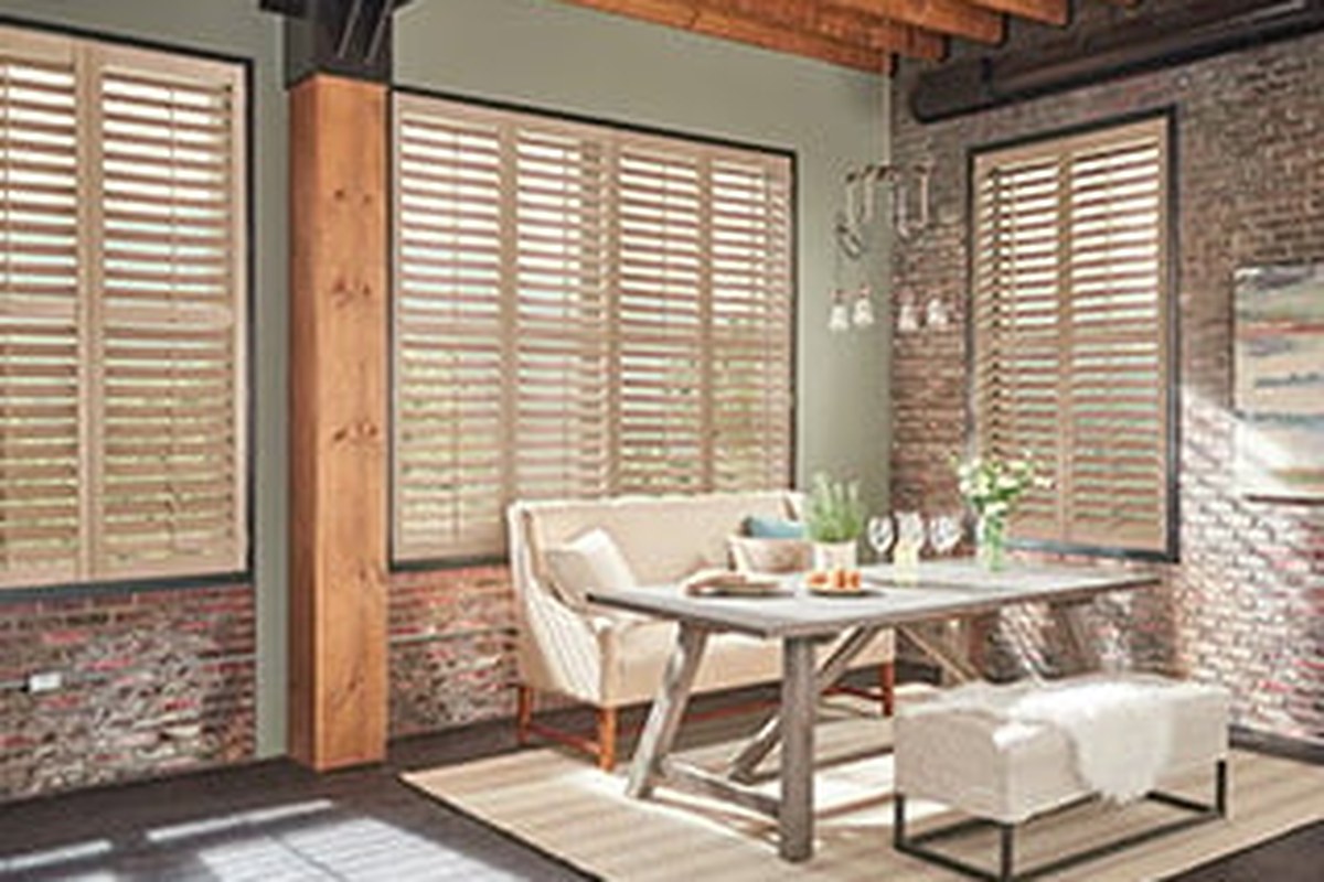 Wood shutters in a dining room by Budget Blinds